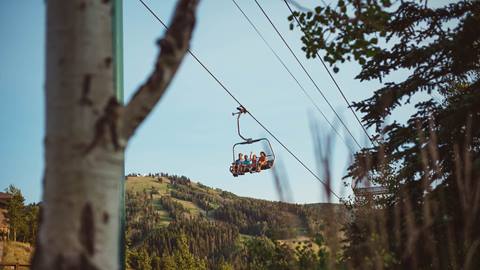 Family of four on a scenic chairlift ride in the summer at Deer Valley.